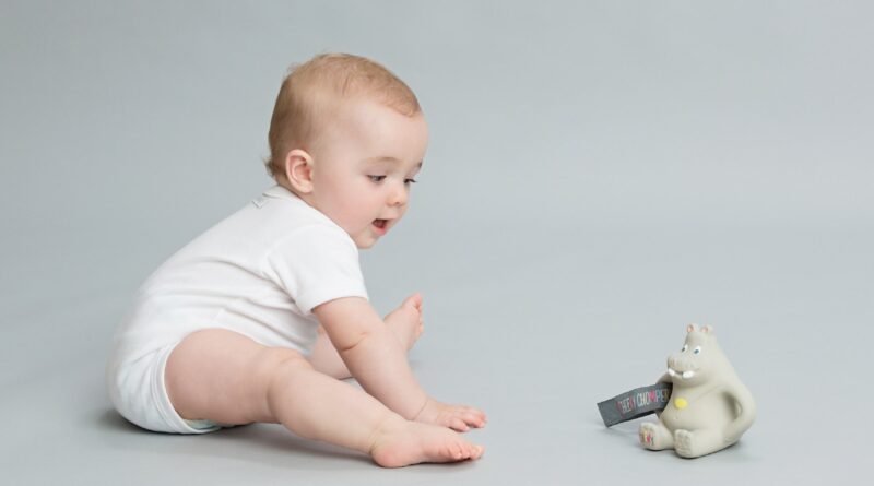 a baby is playing with a toy bear