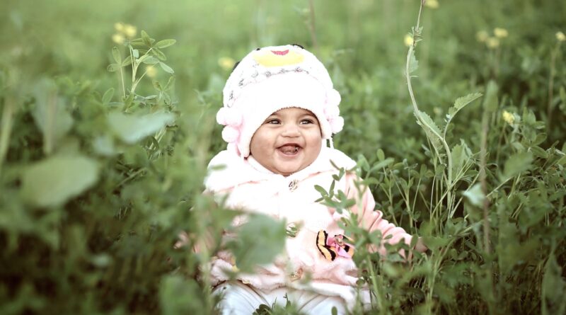 Toddler Wearing Whit Cap on Green Field