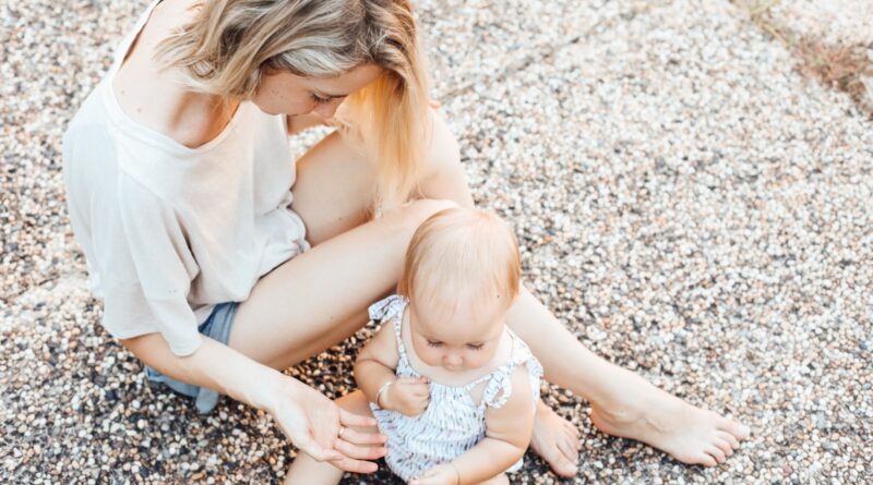 woman and a baby sitting on the ground