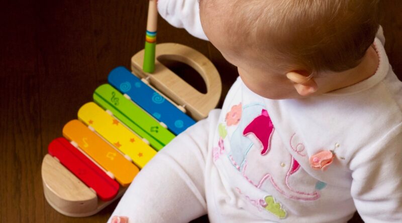 baby playing multicolored xylophone toy